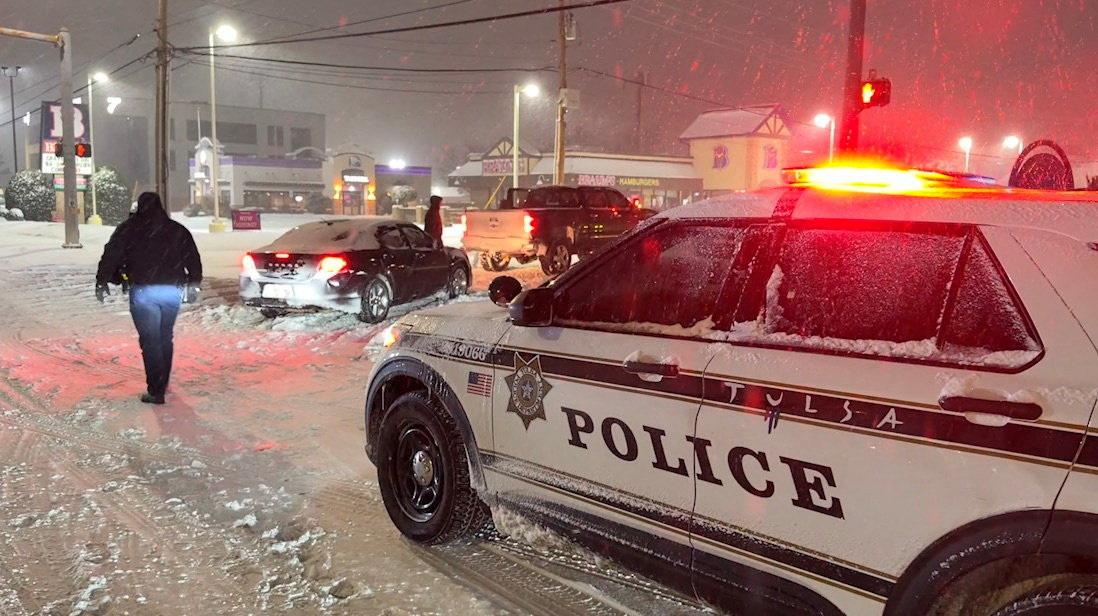 Polizeiauto steht vor während des Sturms liegengebliebenen Fahrzeugenin Tulsa, Oklahoma