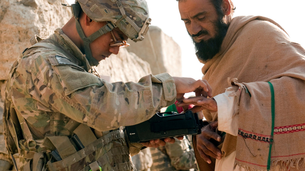 US-Soldat und afghanischer Mann mit einem Biometrie-Gerät