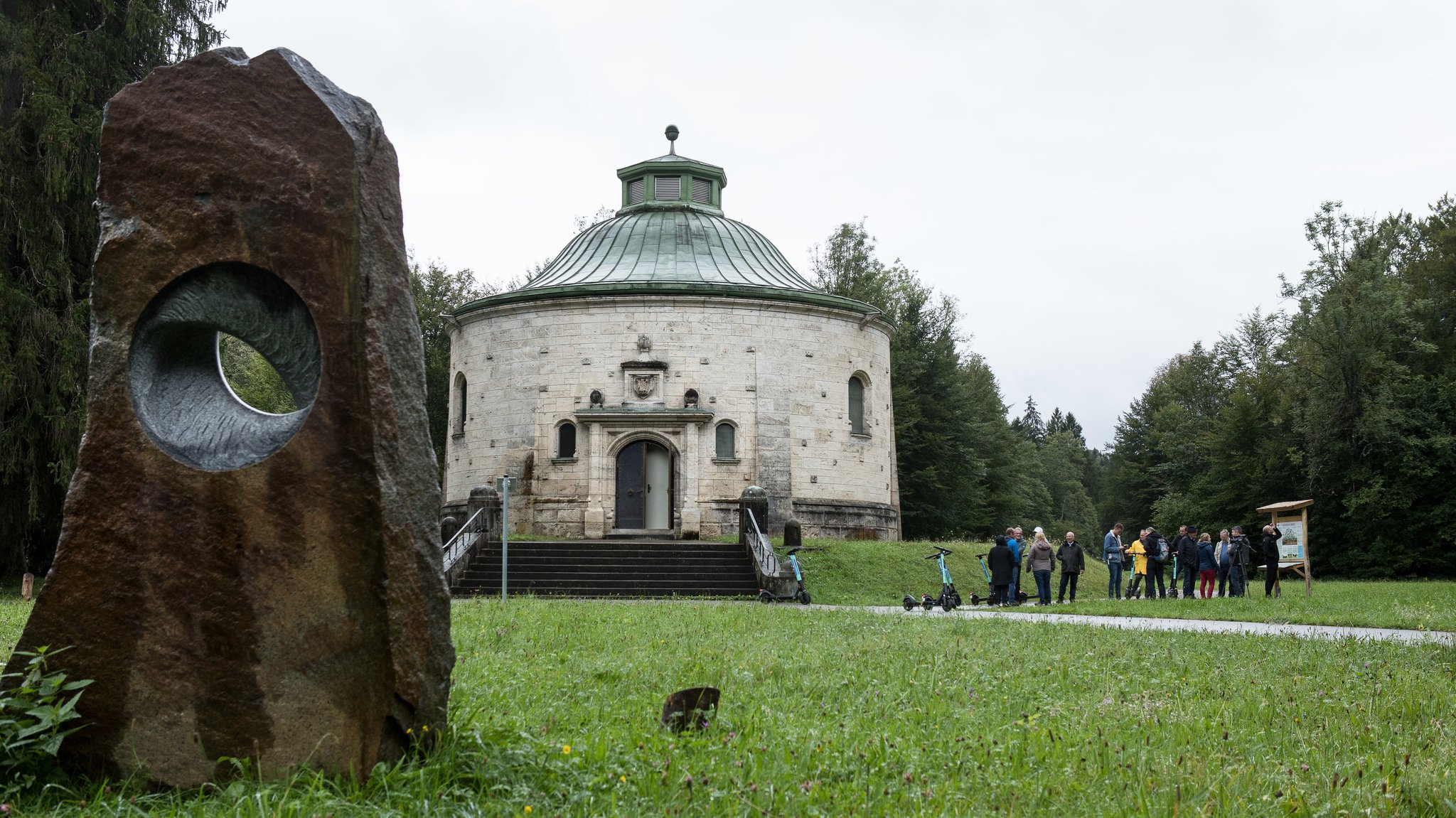 Eine Schautafel neben dem Wasserschloss Reisach. Im Vordergrund die Skulptur Mond-Phasen aus Granit.