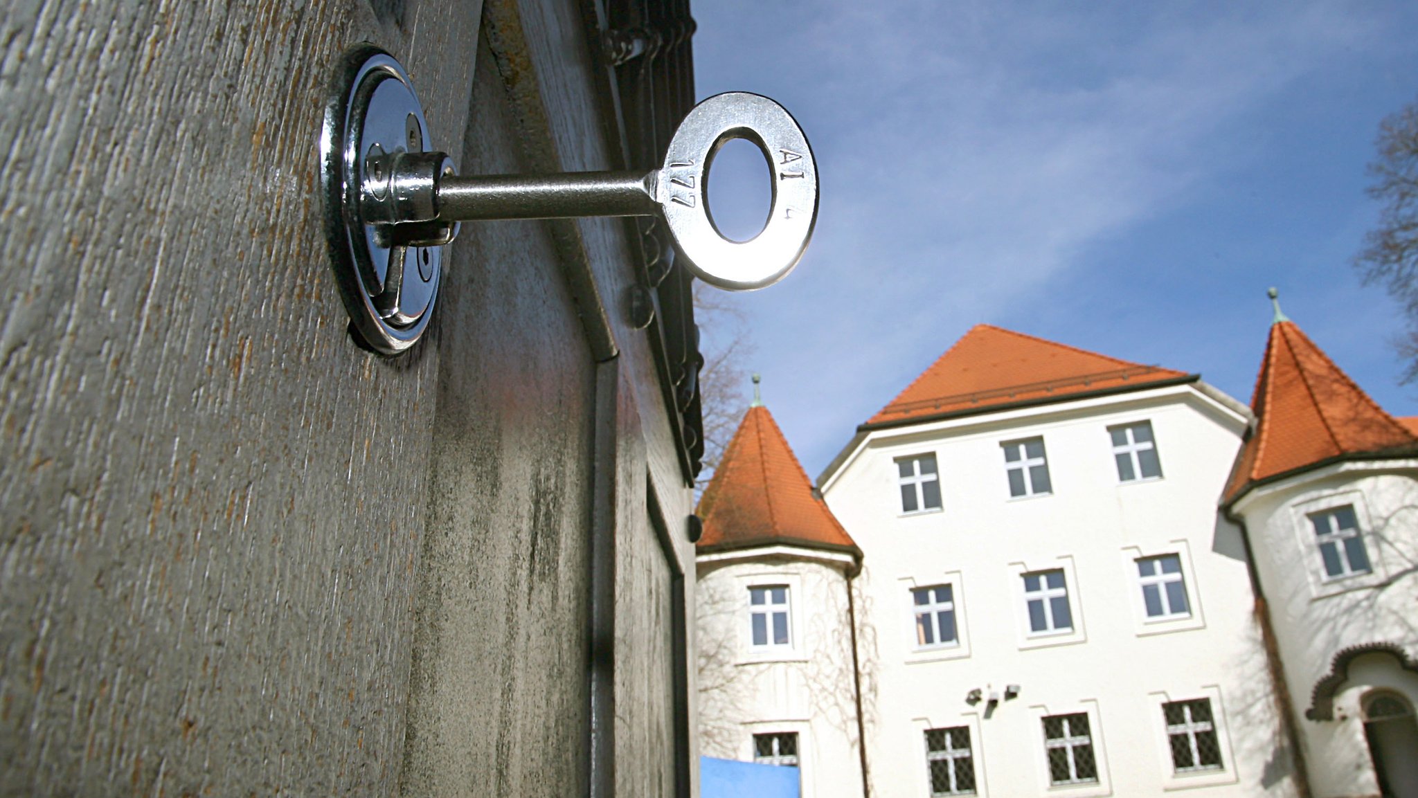 Im Schloss der geöffneten Türe des Eingangsbereiches der Justizvollzugsanstalt Aichach steckt ein Schlüssel.