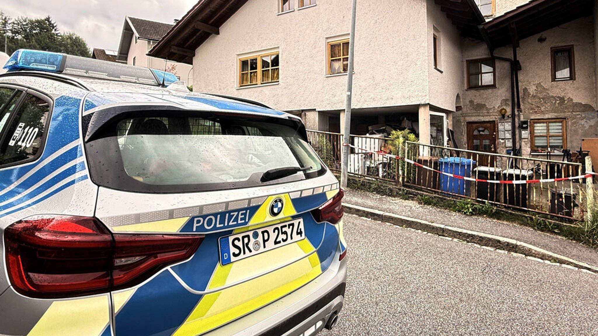 22.07.2025, Bayern, Zwiesel: Ein Auto der Polizei steht vor einem Mehrfamilienhaus. In dem Haus im niederbayerischen Zwiesel sind drei Leichen gefunden worden. Man gehe derzeit von einem Tötungsdelikt aus, sagte eine Polizeisprecherin. Ein Verdächtiger sei in Österreich festgenommen worden. Foto: Christine Vincon/dpa - ACHTUNG: Eine Hausnummer wurde aus rechtlichen Gründen gepixelt +++ dpa-Bildfunk +++ | Bild: dpa-Bildfunk/Christine Vincon 22.07.2025, Bayern, Zwiesel: Ein Auto der Polizei steht vor einem Mehrfamilienhaus. In dem Haus im niederbayerischen Zwiesel sind drei Leichen gefunden worden. Man gehe derzeit von einem Tötungsdelikt aus, sagte eine Polizeisprecherin. Ein Verdächtiger sei in Österreich festgenommen worden. Foto: Christine Vincon/dpa - ACHTUNG: Eine Hausnummer wurde aus rechtlichen Gründen gepixelt +++ dpa-Bildfunk +++