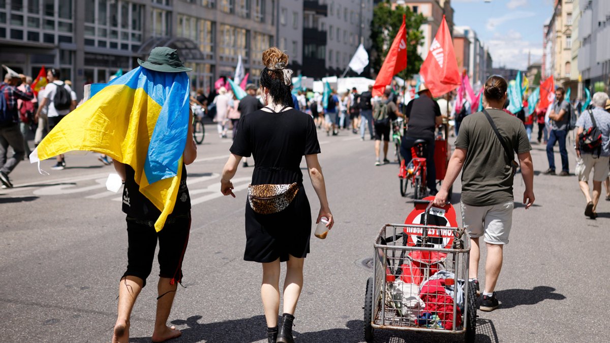 München: Ein Teilnehmer trägt eine Fahne der Ukraine bei einer Demonstration der G7-Kritiker für einen besseren Klima- und Artenschutz und gegen Hunger und Armut. 
