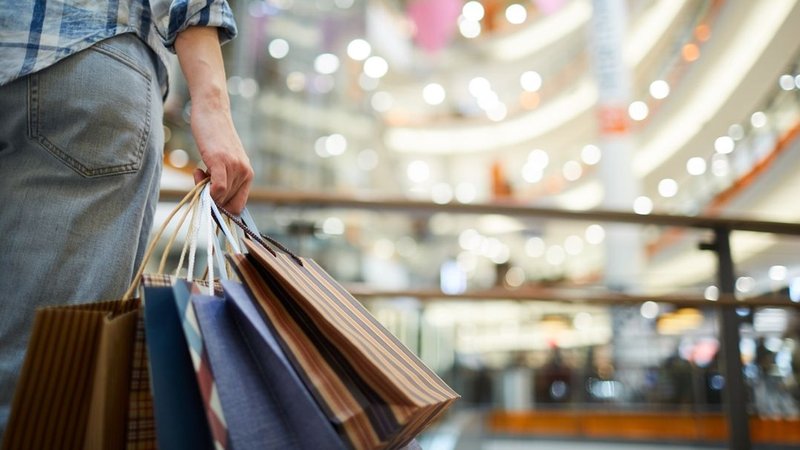 Eine Person hält viele Einkaufstaschen in einem Einkaufszentrum. | Bild: stock.adobe.com/Seventyfour Eine Person hält viele Einkaufstaschen in einem Einkaufszentrum.