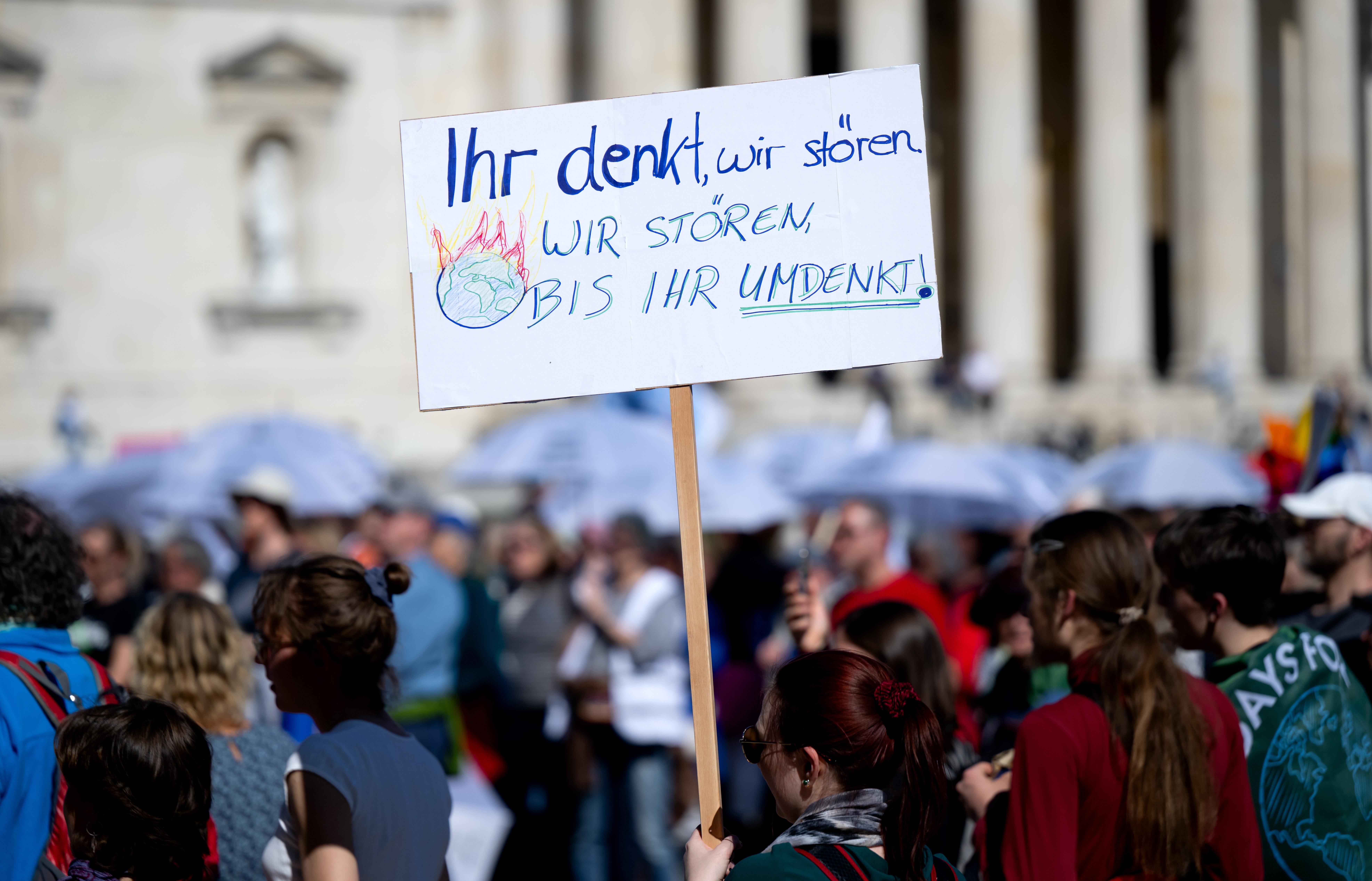 ARCHIVBILD vom 11.04.2025: Zahlreiche Menschen nehmen auf dem Königsplatz an einer Demonstration von Fridays for Future zum Klimastreik teil und halten ein Schild mit der Aufschrift „Ihr denkt wir stören - wir stören bis ihr umdenkt“ in den Händen.