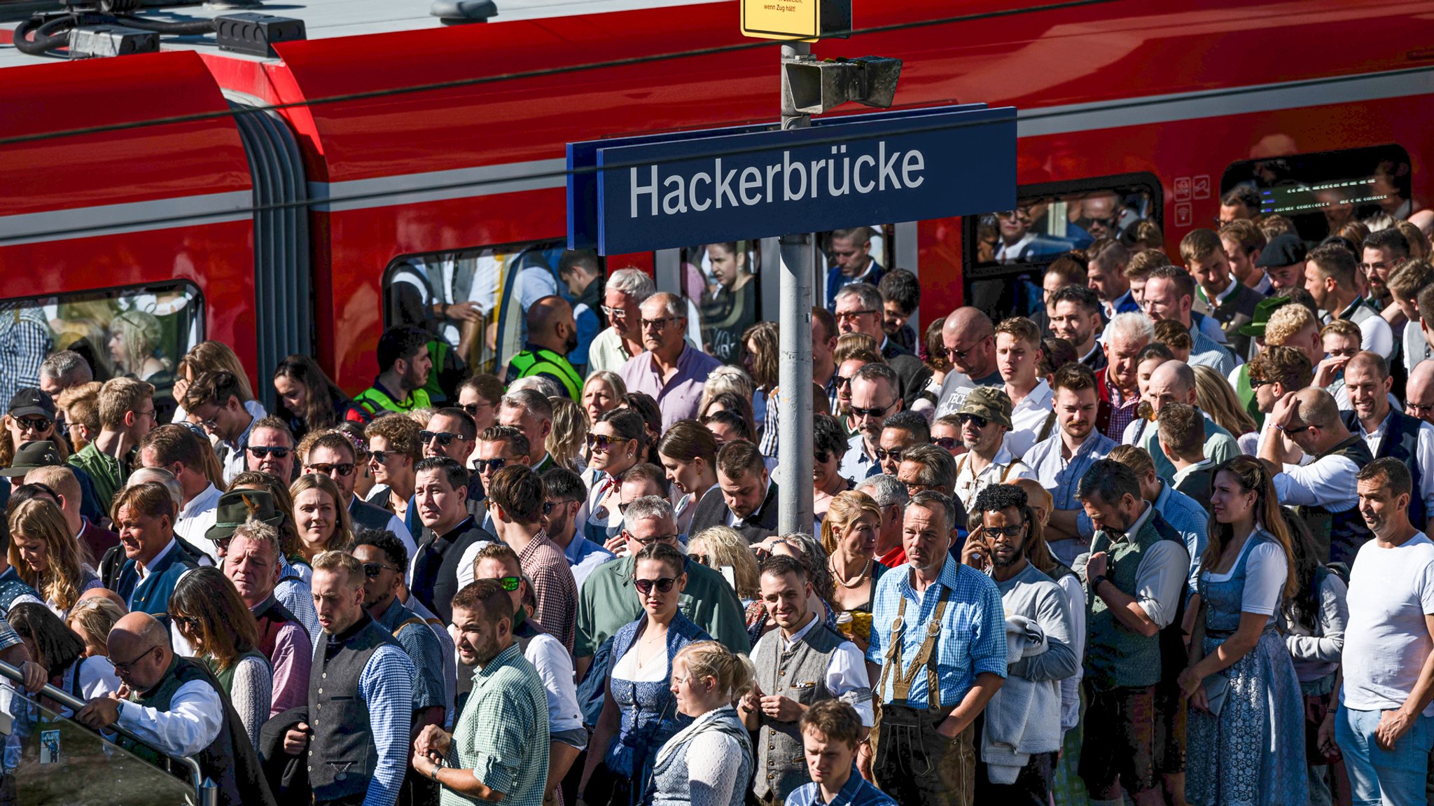 Oktoberfestbesucher stehen auf dem Weg zur Festwiese an der S-Bahn-Station Hackerbrücke (Archivbild vom 16.9.2023).