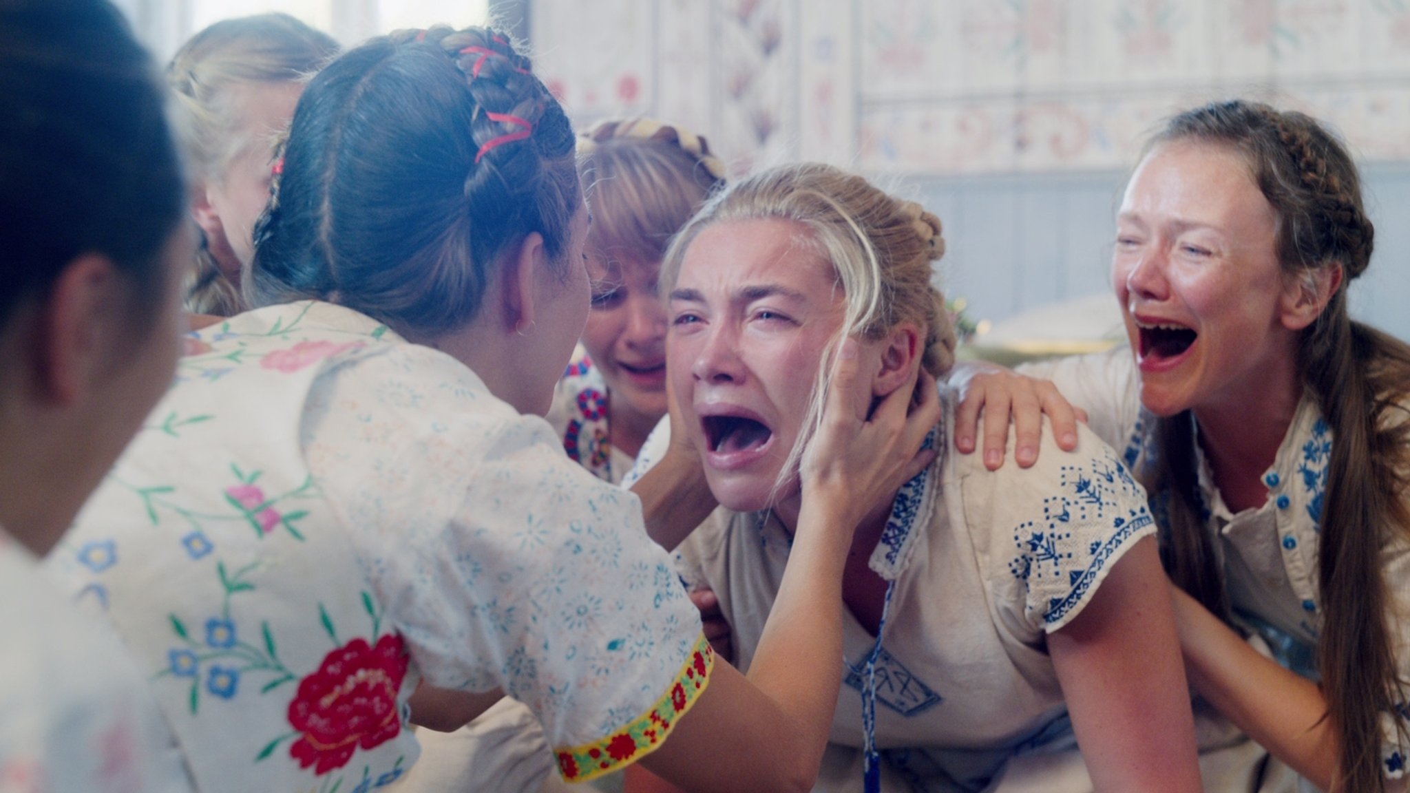 Die weinende Florence Pugh wird von Sektenmitgliedern am Kopf gefasst. 