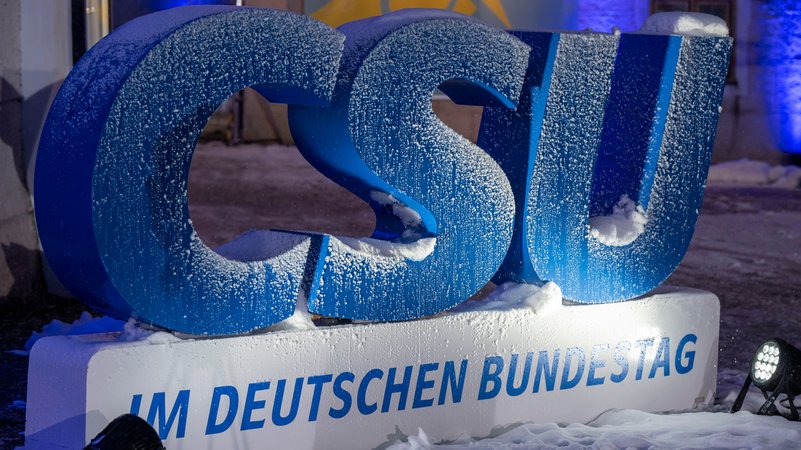 Verschneites CSU-Logo vor dem Kloster Seeon | Bild: picture alliance/dpa | Peter Kneffel Verschneites CSU-Logo vor dem Kloster Seeon