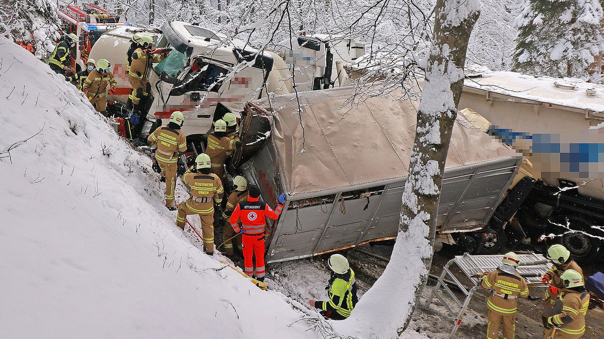 Rettungskräfte bergen die stark beschädigten Lkw.