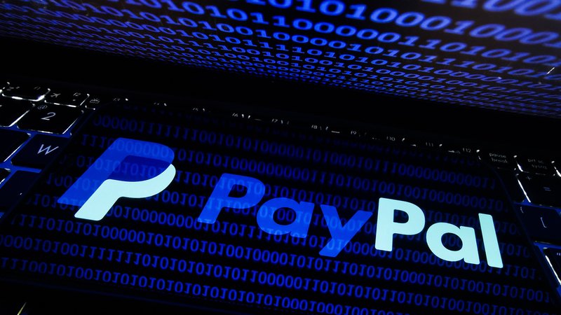 Paypal-Logo auf schwarz-blauem Bildschirm mit vielen Nullen und Einsen. | Bild: picture alliance / Jakub Porzycki Paypal-Logo auf schwarz-blauem Bildschirm mit vielen Nullen und Einsen.