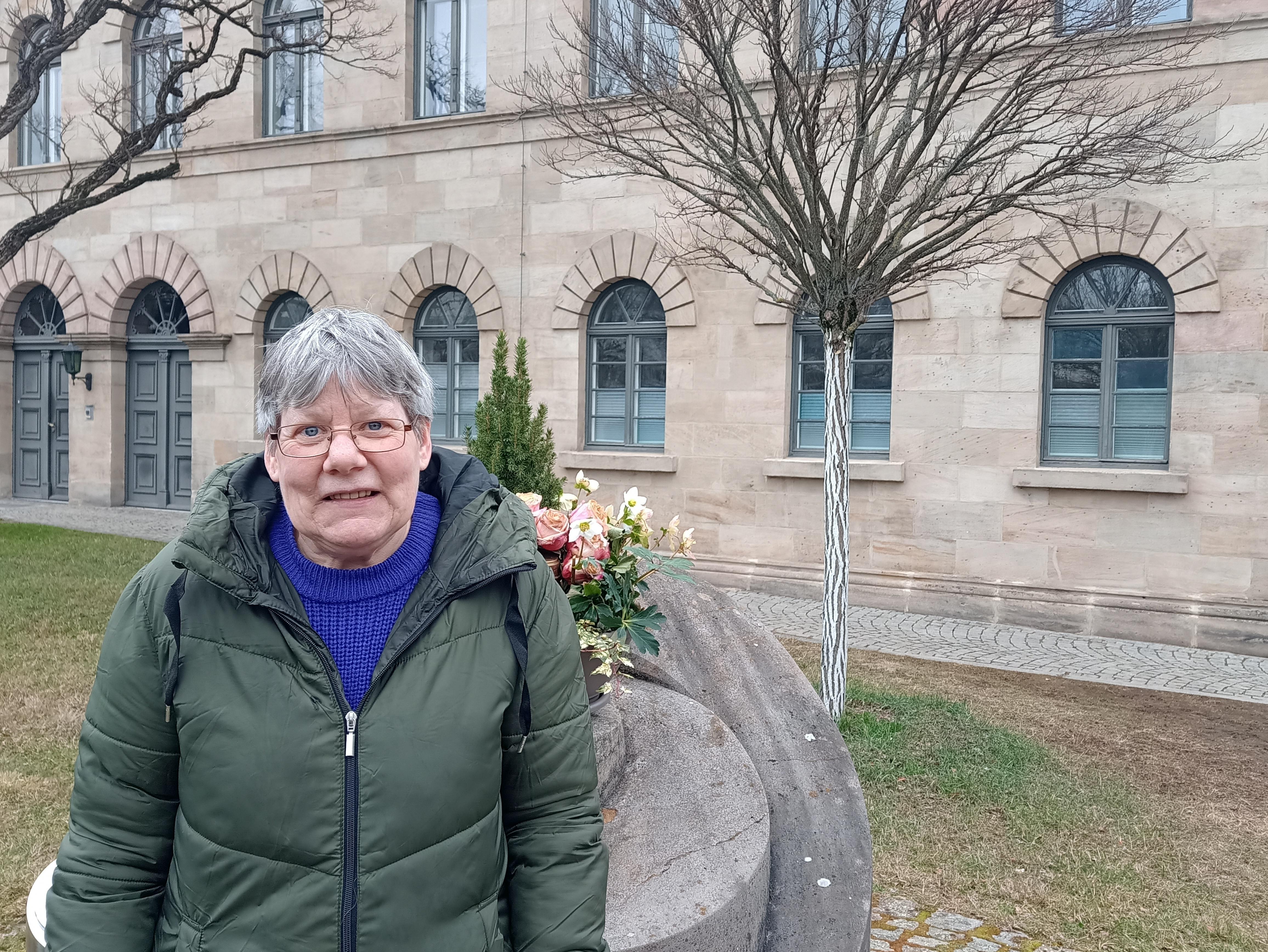 Eine Frau an einem Gedenkstein.
