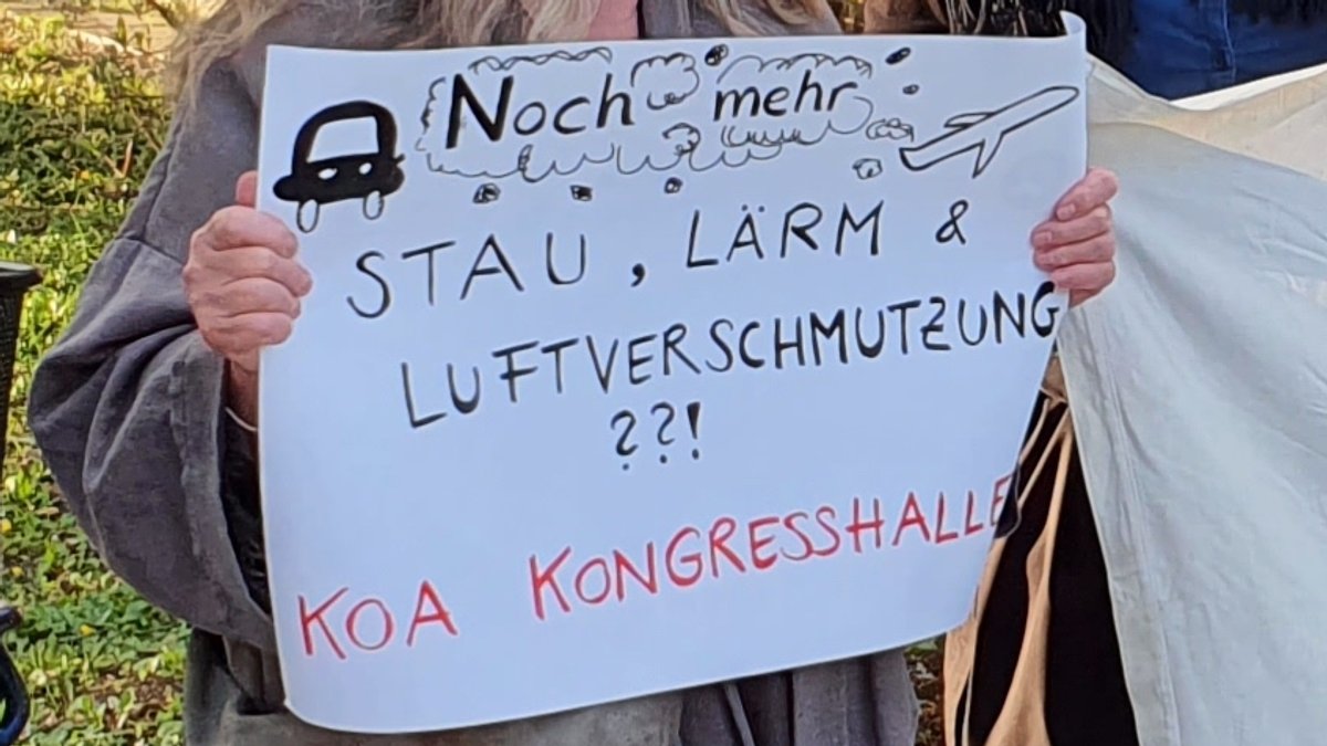 Nahaufnahme eines handgeschriebenen Plakats, auf dem steht: "Noch mehr Stau, Lärm und Luftverschmutzung? Koa Kongresshalle"