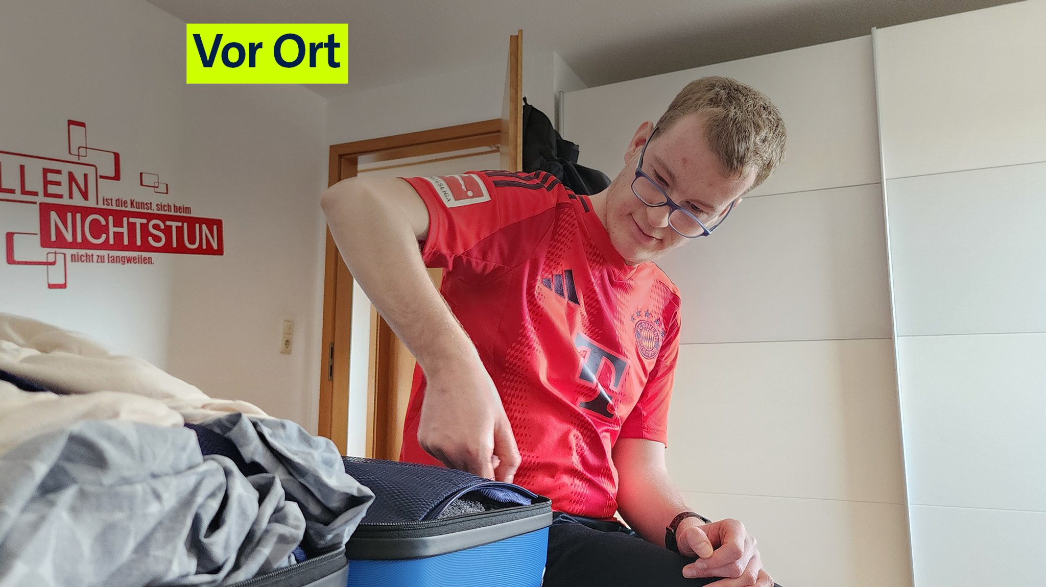 Lars sitzt auf seinem Bett und packt seinen Koffer