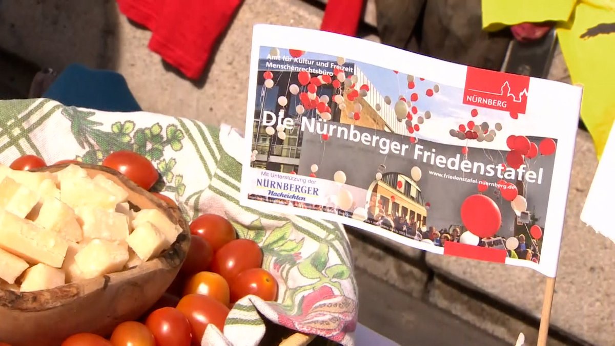 Eine Schüssel mit Tomaten und Käse neben einem Fähnchen, auf dem steht: "Die Nürnberger Friedenstafel"