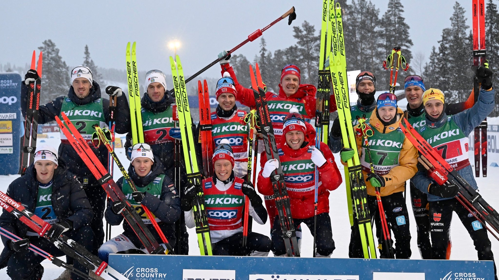 ARCHIV - 03.12.2023, Schweden, Gällivare: Ski nordisch/ Langlauf: Weltcup, Staffel 4 x 7,5 km, Herren:  Team Schweden mit Johan Häggström (l-r), Calle Halfvarsson, Leo Johansson und Edvin Anger, die den zweiten Platz belegten, Team Norwegen mit Paal Golberg, Martin Loewstroem Nyenget, Simen Hegstad Krüger und Jan Thomas Jenssen, die den ersten Platz belegten, und Team Deutschland mit Janosch Brugger, Albert Kuchler, Friedrich Moch und Anian Sossau, die den dritten Platz belegten, lächeln nach dem Rennen . 