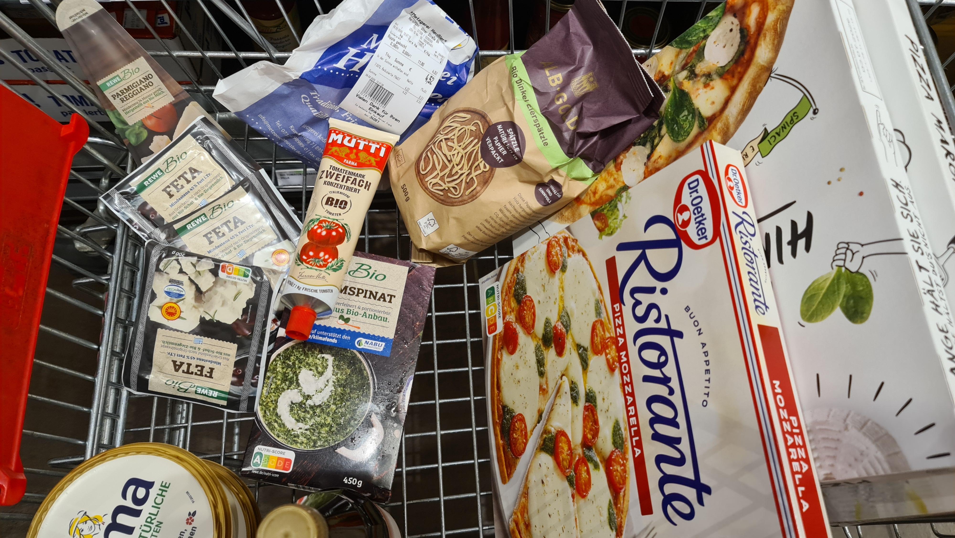 Ein Einkaufswagen von oben mit Lebensmitteln aus konventionellem und ökologischem Anbau.