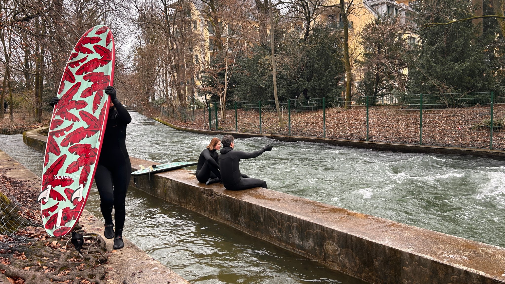 Surfer, Wasser und ein Zaun