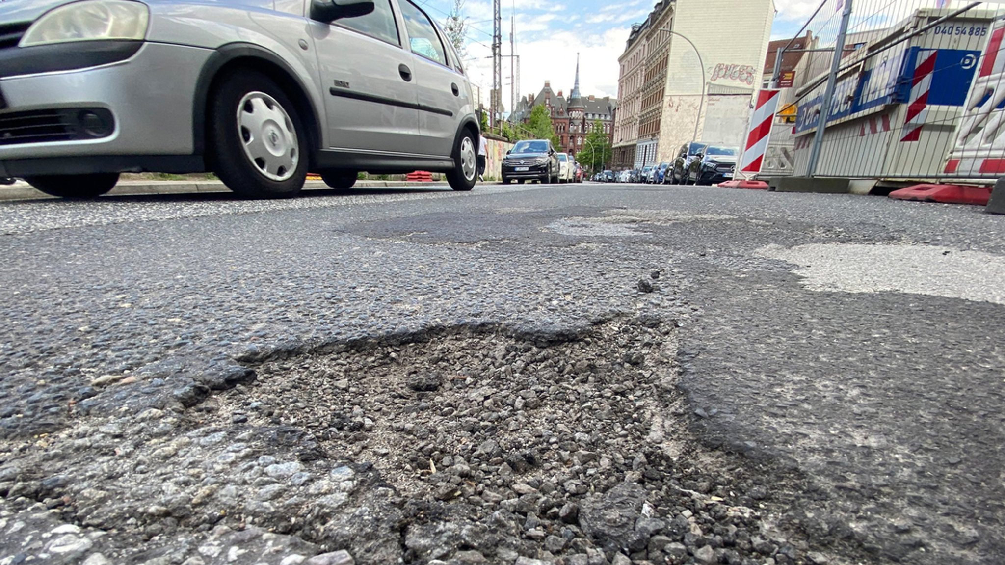 Ein Schlagloch ist auf einer Straße in der Innenstadt zu sehen.