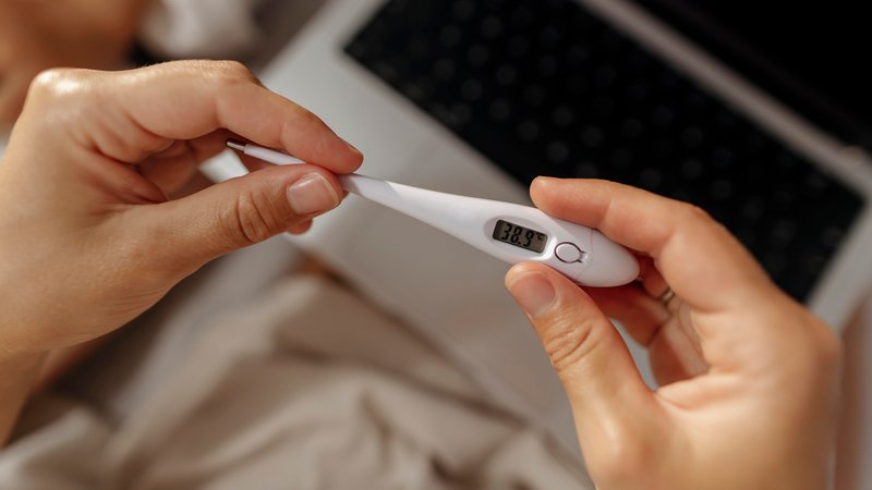 Hände, die ein Fieberthermometer halten, es zeigt eine Temperatur von 38,9 an. | Bild: picture alliance / Westend61 | Svetlana Iakusheva Hände, die ein Fieberthermometer halten, es zeigt eine Temperatur von 38,9 an.