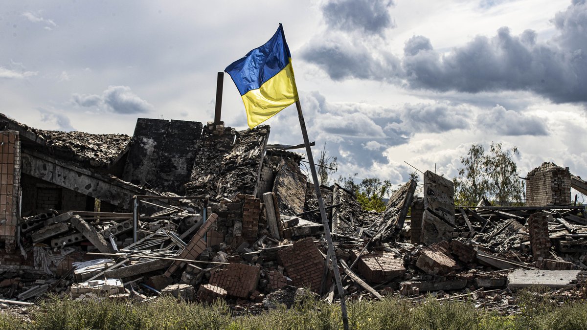 Eine ukrainische Flagge weht vor Trümmern in Dolyna, unweit der ostukrainischen Stadt Lyman.