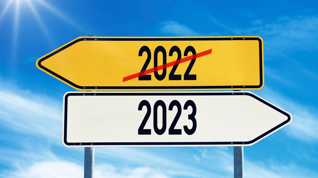 Wegweiser vor blauem Himmel mit der Aufschrift: 2022, 2023. Das Jahr 2022 ist durchgestrichen