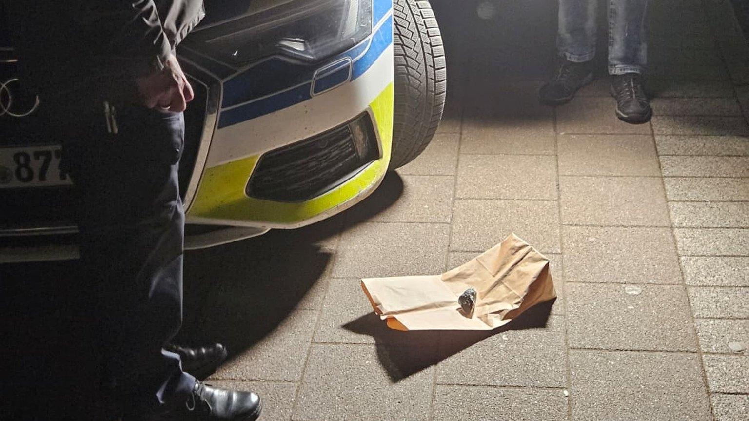 Polizisten stehen vor dem Meteoriten, der am Sonntagabend ein Hausdach in Rheinland-Pfalz beschädigt hat.