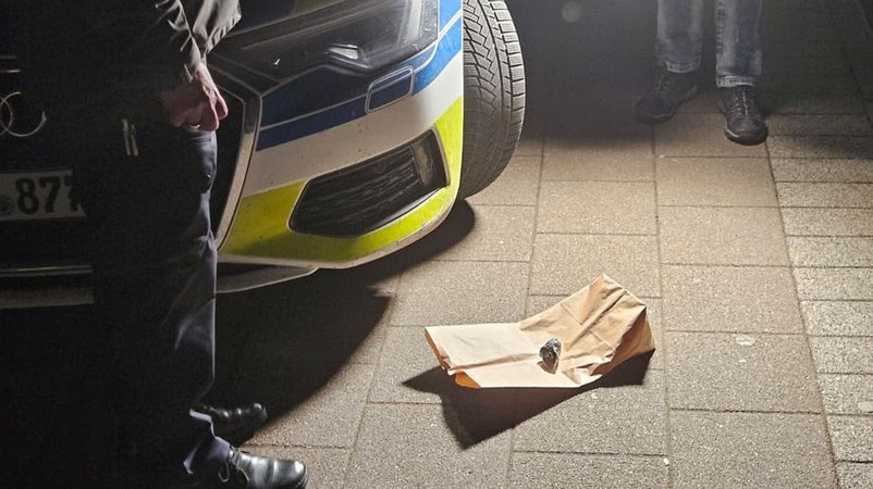 Polizisten stehen vor dem Meteoriten, der am Sonntagabend ein Hausdach in Rheinland-Pfalz beschädigt hat. | Bild: dpa-Bildfunk/Thomas Frey Polizisten stehen vor dem Meteoriten, der am Sonntagabend ein Hausdach in Rheinland-Pfalz beschädigt hat.