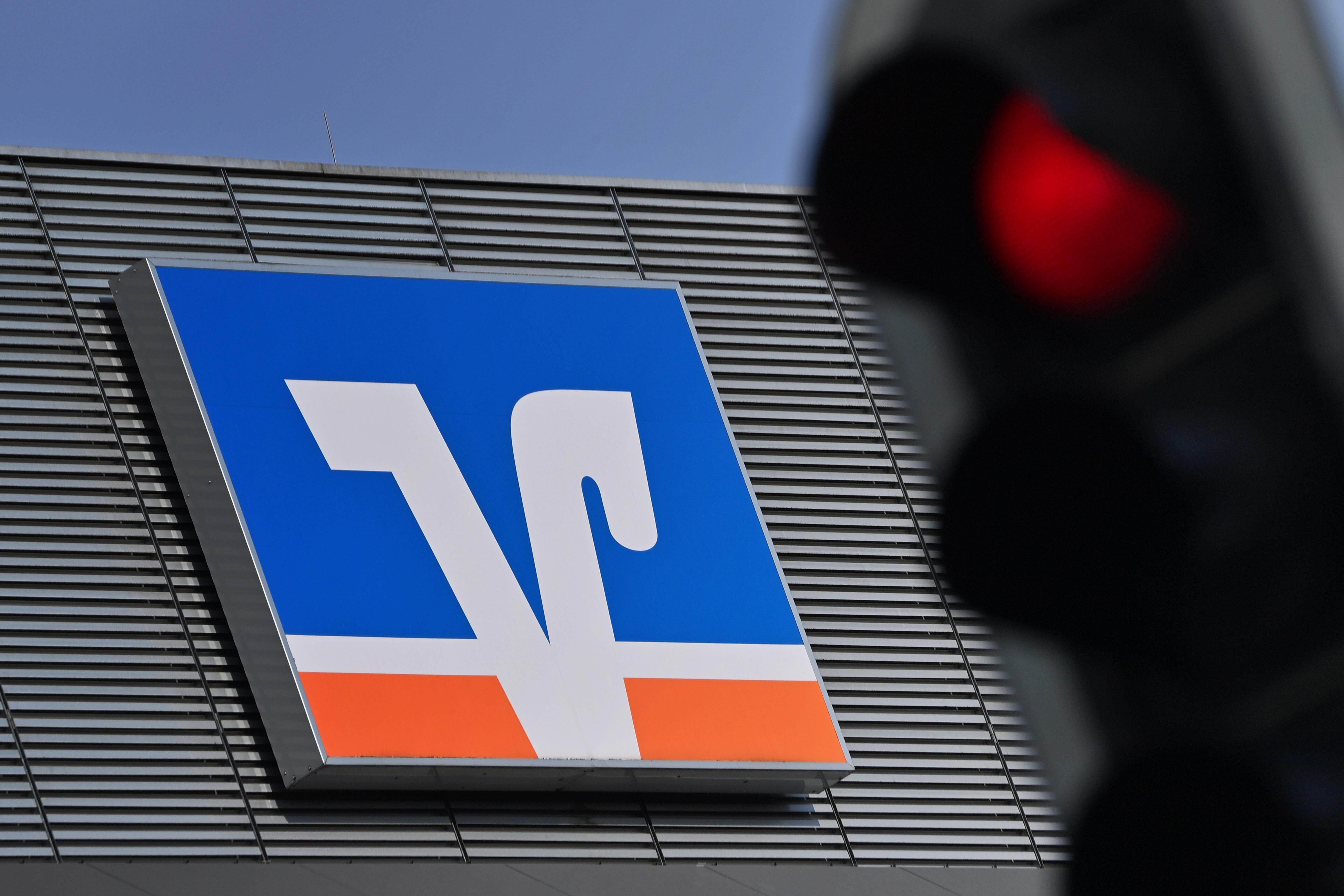 Symbolbild für Volksbanken, die unter Fusionsdruck stehen: Ein VR-Logo mit einer roten Ampel.