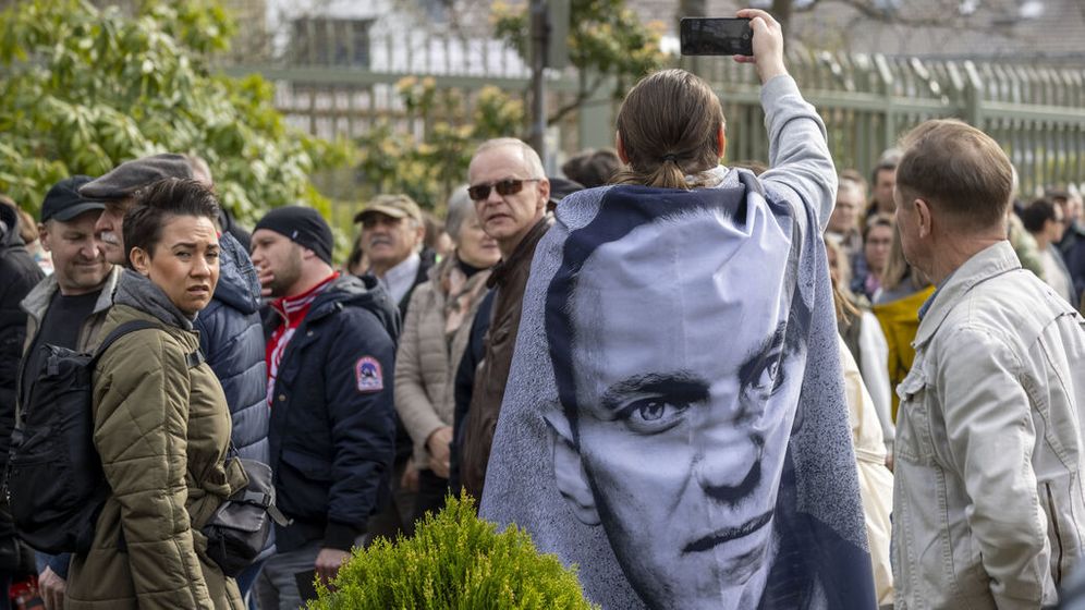 Ein Demonstrant mit einem Bild über den Schultern von dem gestorbenen Regimegegner Alexei Nawalny steht vor dem russischen Generalkonsulat. | Bild:dpa-Bildfunk/Thomas Banneyer