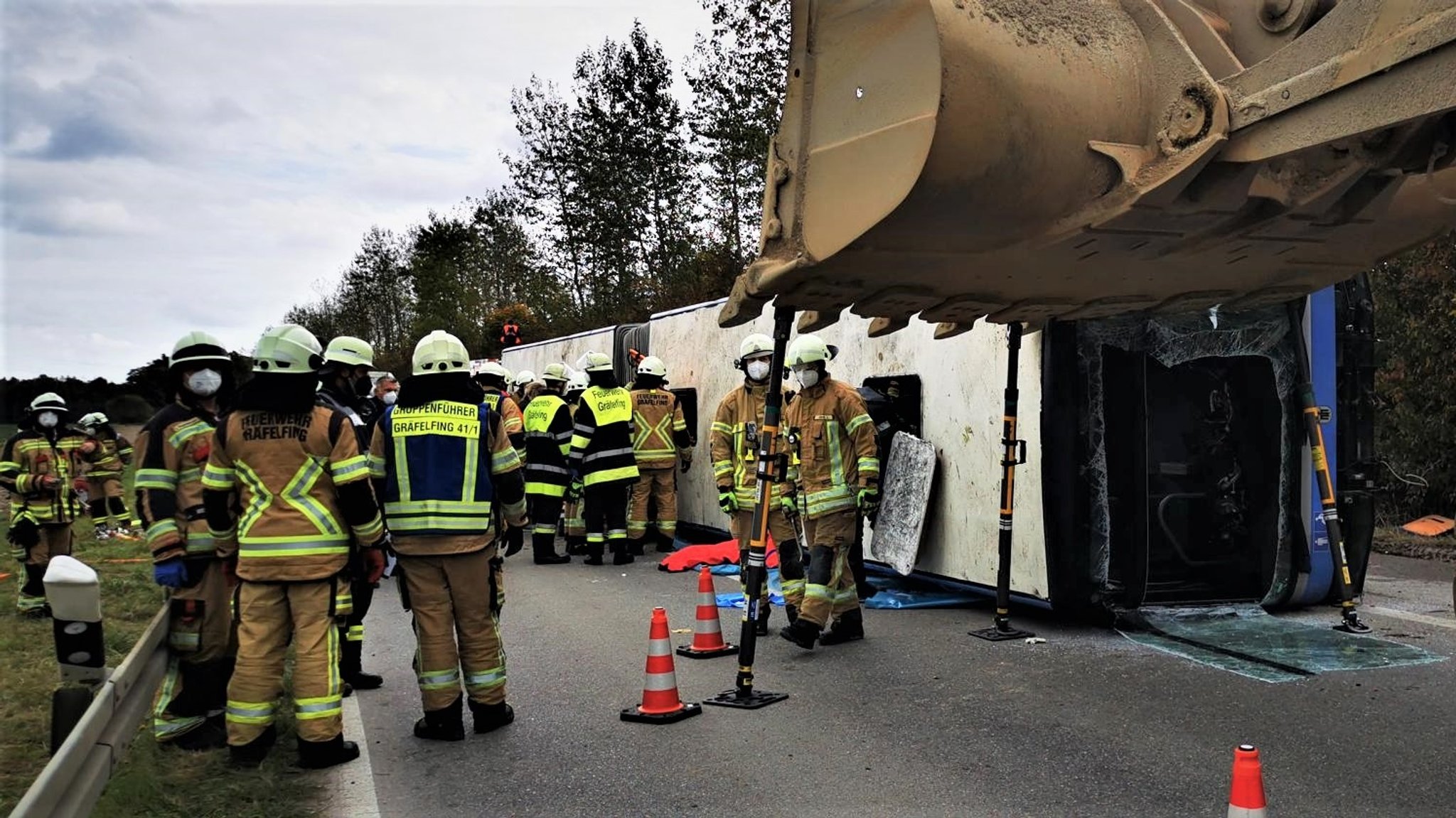 Umgestürzter Bus und zahlreiche Einsatzkräfte.