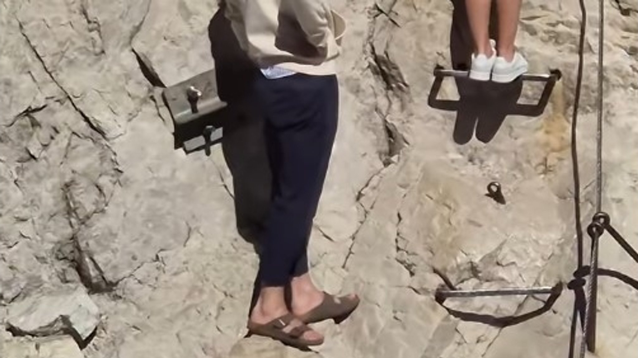 Ein junger Mann absolviert den Klettersteig zum Gipfel der Zugspitze in knapp 3.000 Metern Höhe mit Sandalen.