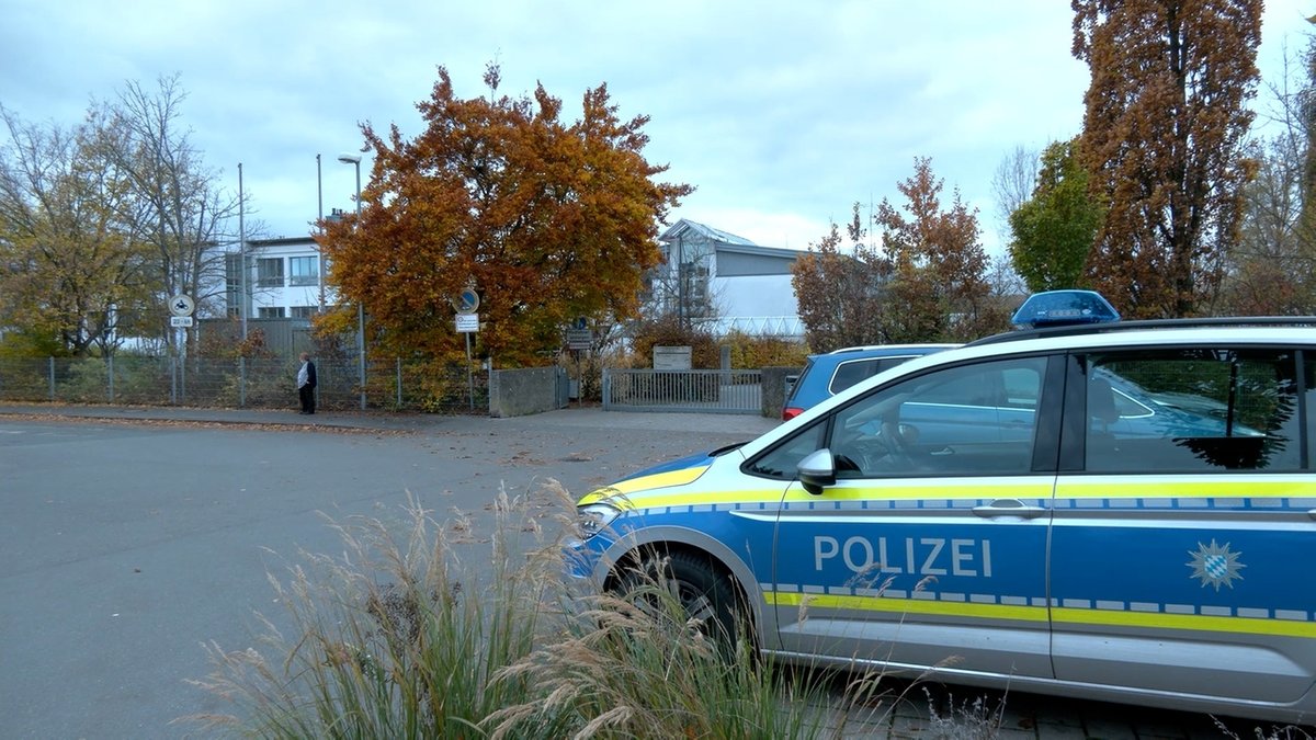 Polizeiauto vor einer Schule.