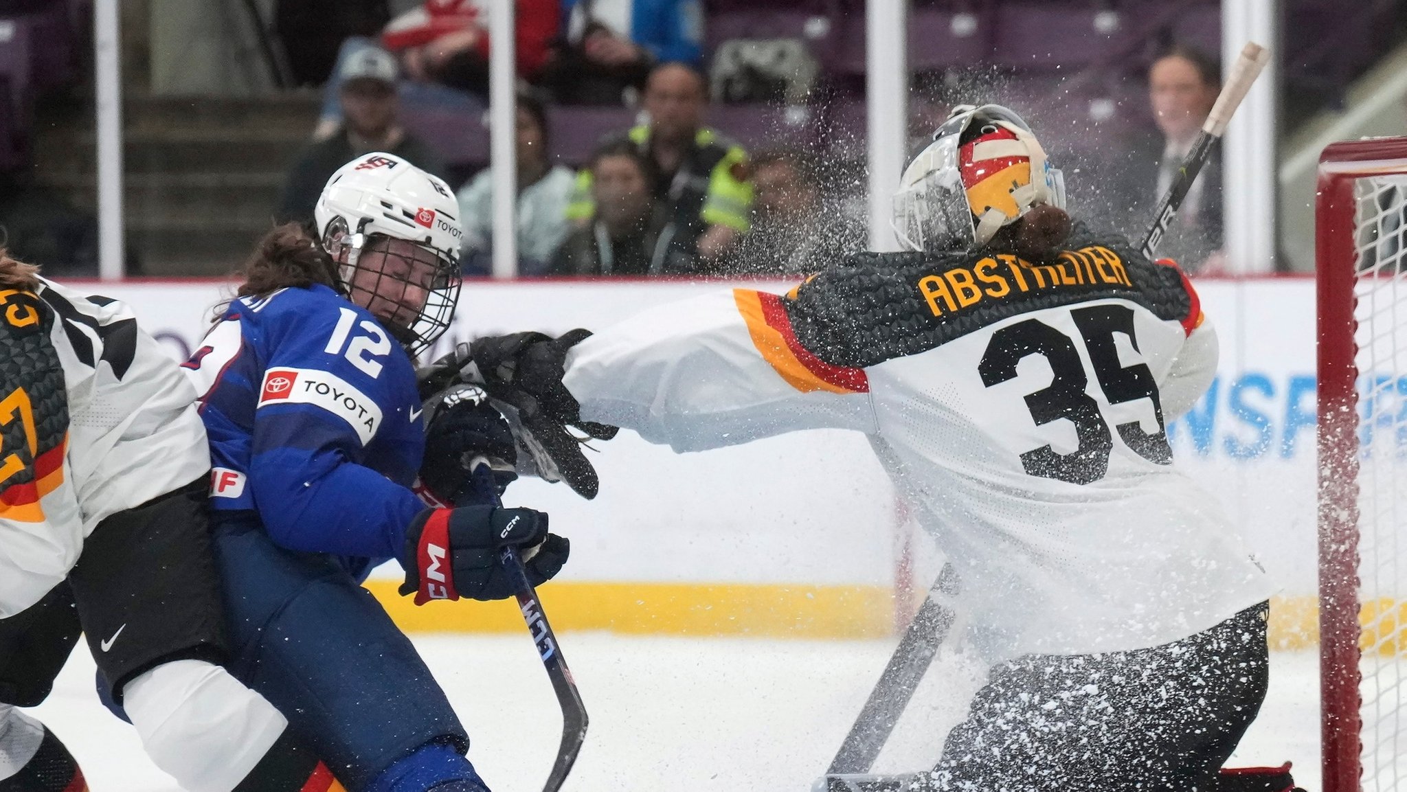 ARCHIV - 13.04.2023, Kanada, Brampton: Eishockey, Frauen: WM, USA - Deutschland, Finalrunde, Viertelfinale. Kelly Pannek (M) aus den USA gegen Torhüterin Sandra Abstreiter (r) und Heidi Strompf aus Deutschland. Torhüterin Sandra Abstreiter ist die Hoffnungsträgerin bei der WM in Utica. (zu dpa: «Eishockey-Pionierin Abstreiter trägt deutsche WM-Hoffnungen») Foto: Nathan Denette/AP/dpa +++ dpa-Bildfunk +++