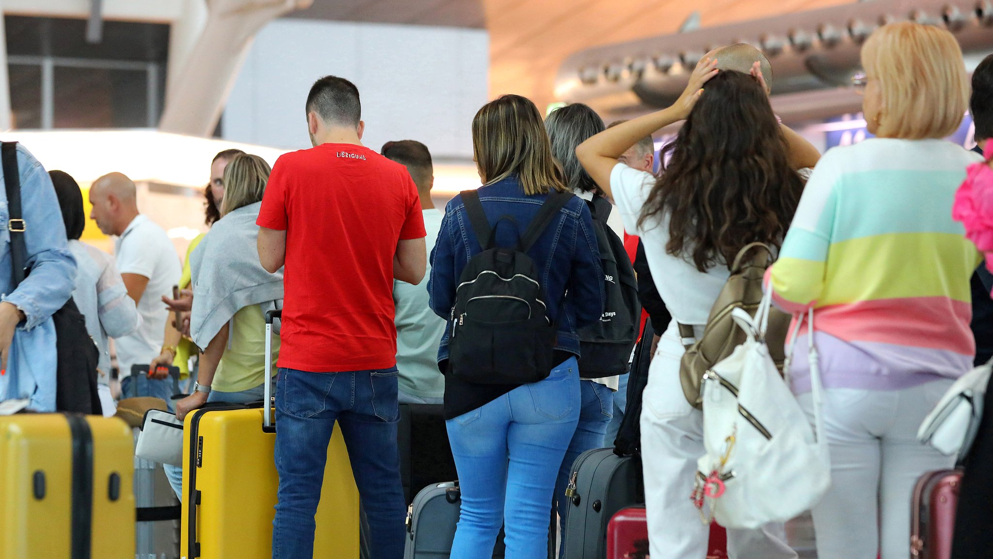 Passagiere warten in einer Schlange auf den Check in