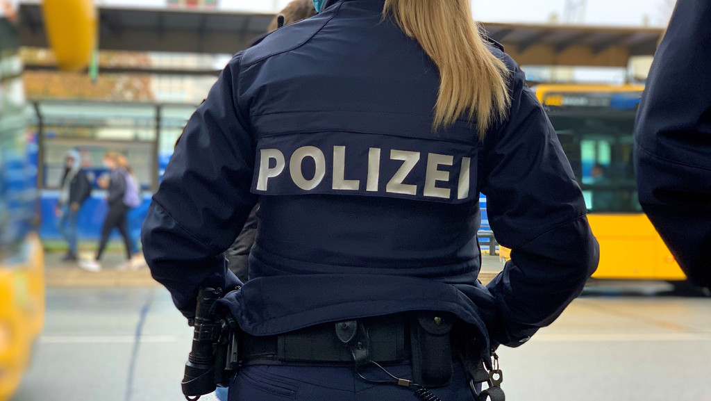 Eine Polizistin kontrolliert eine Bushaltestelle (Symbolbild). 