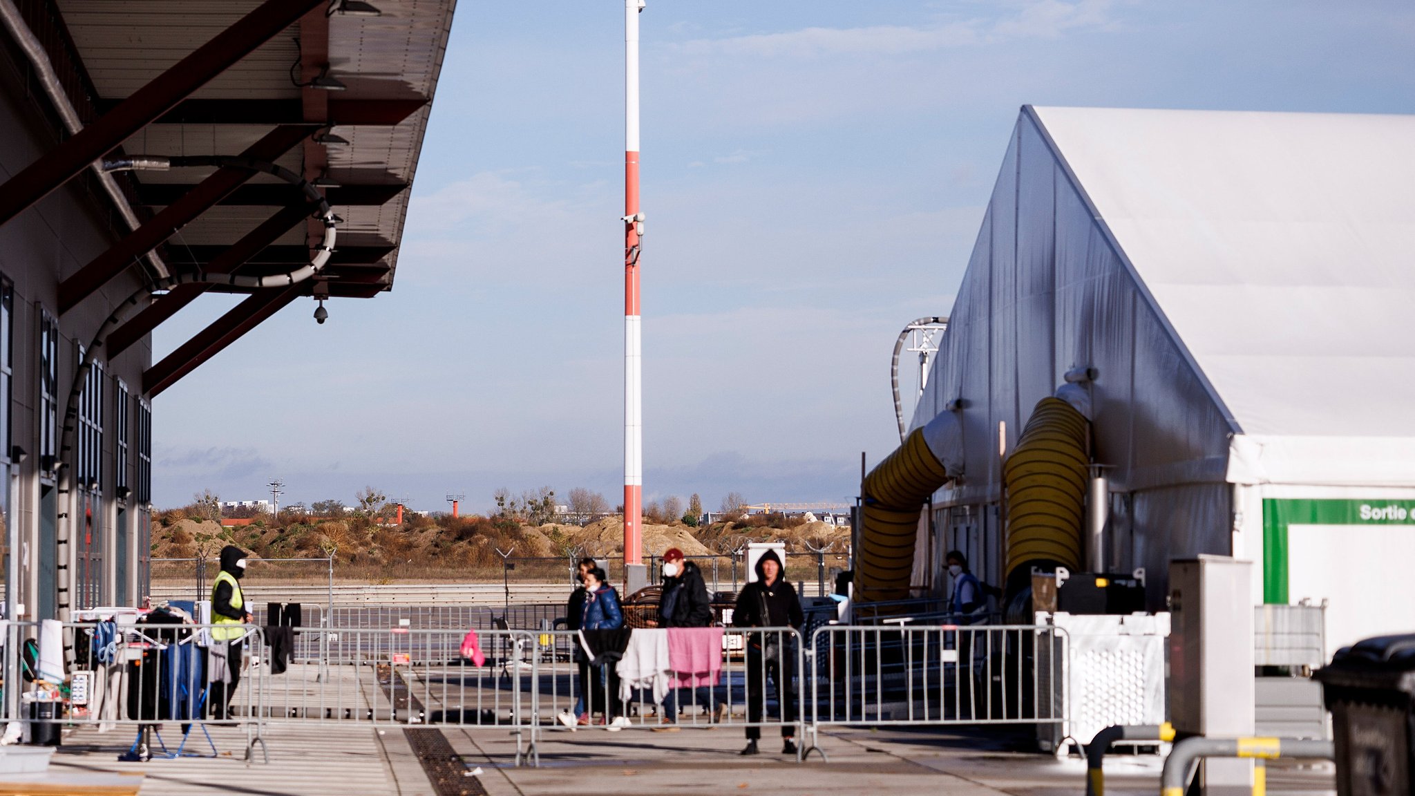 09.11.22, Berlin: Mitarbeiter der Security stehen vor einem Unterkunftszelt für Geflüchtete im Ukraine-Ankunftszentrum Tegel.