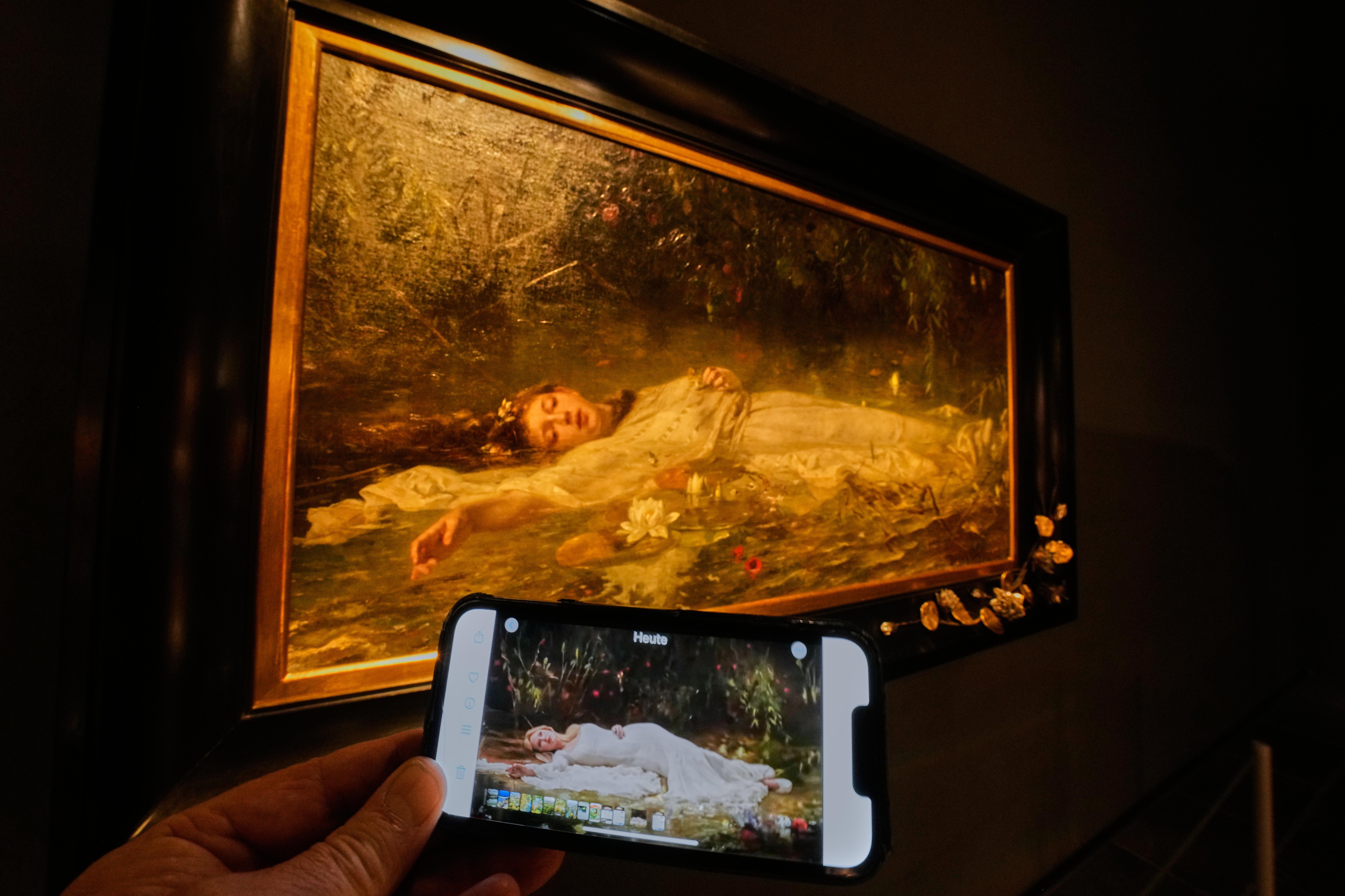 Das Original-Gemälde im Museum Wiesbaden mit einem Ausschnitt des Videos auf einem Handydisplay | Bild:picture alliance / ASSOCIATED PRESS | Michael Probst