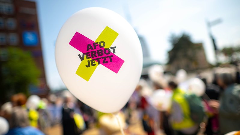 Archivbild (11.06.2025, Bremerhaven): Protestierende mit Plakaten und Luftballons fordern ein AfD-Verbot. | Bild: picture alliance/dpa | Sina Schuldt Archivbild (11.06.2025, Bremerhaven): Protestierende mit Plakaten und Luftballons fordern ein AfD-Verbot.