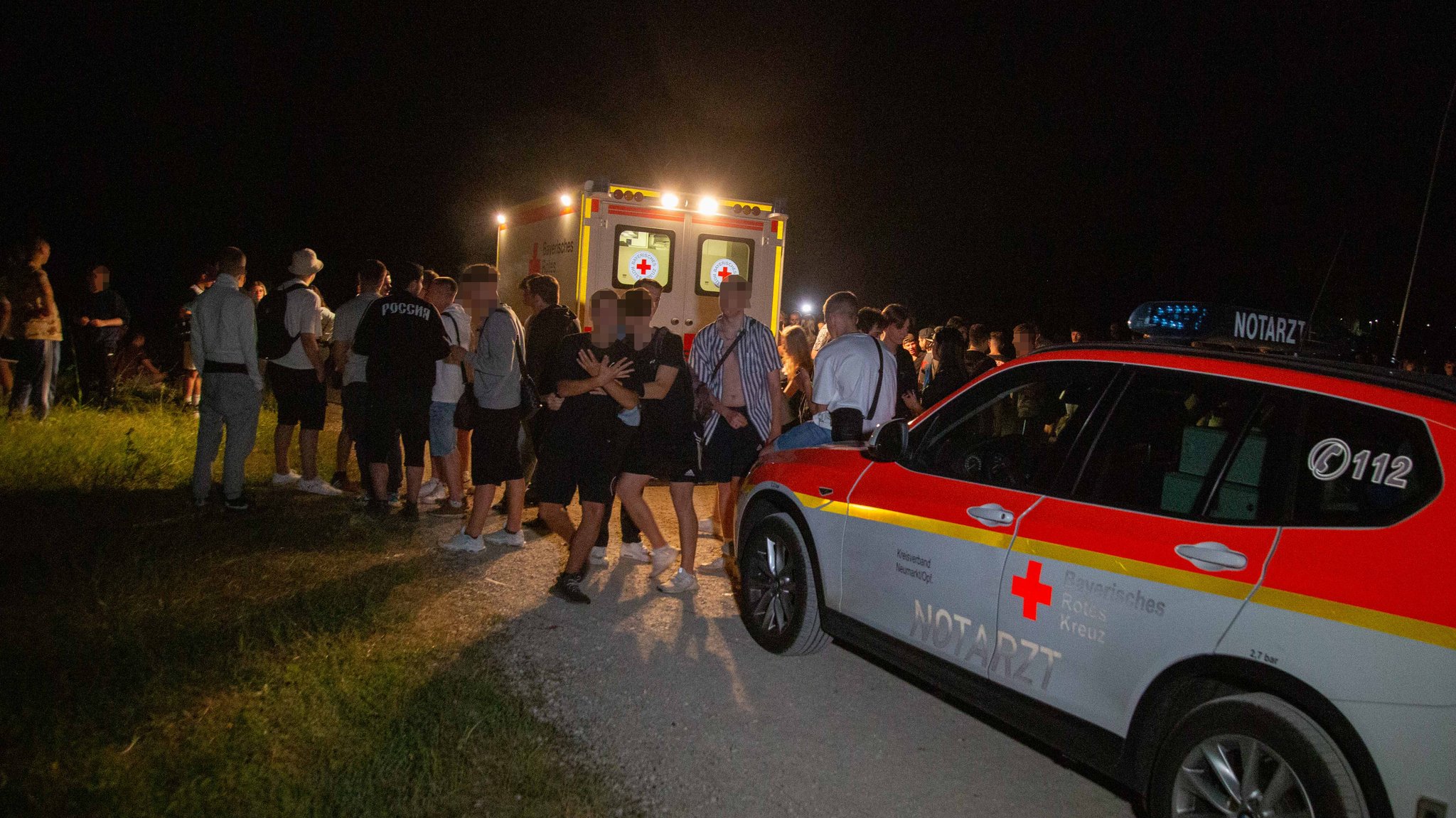 Partyvolk und Rettungswagen