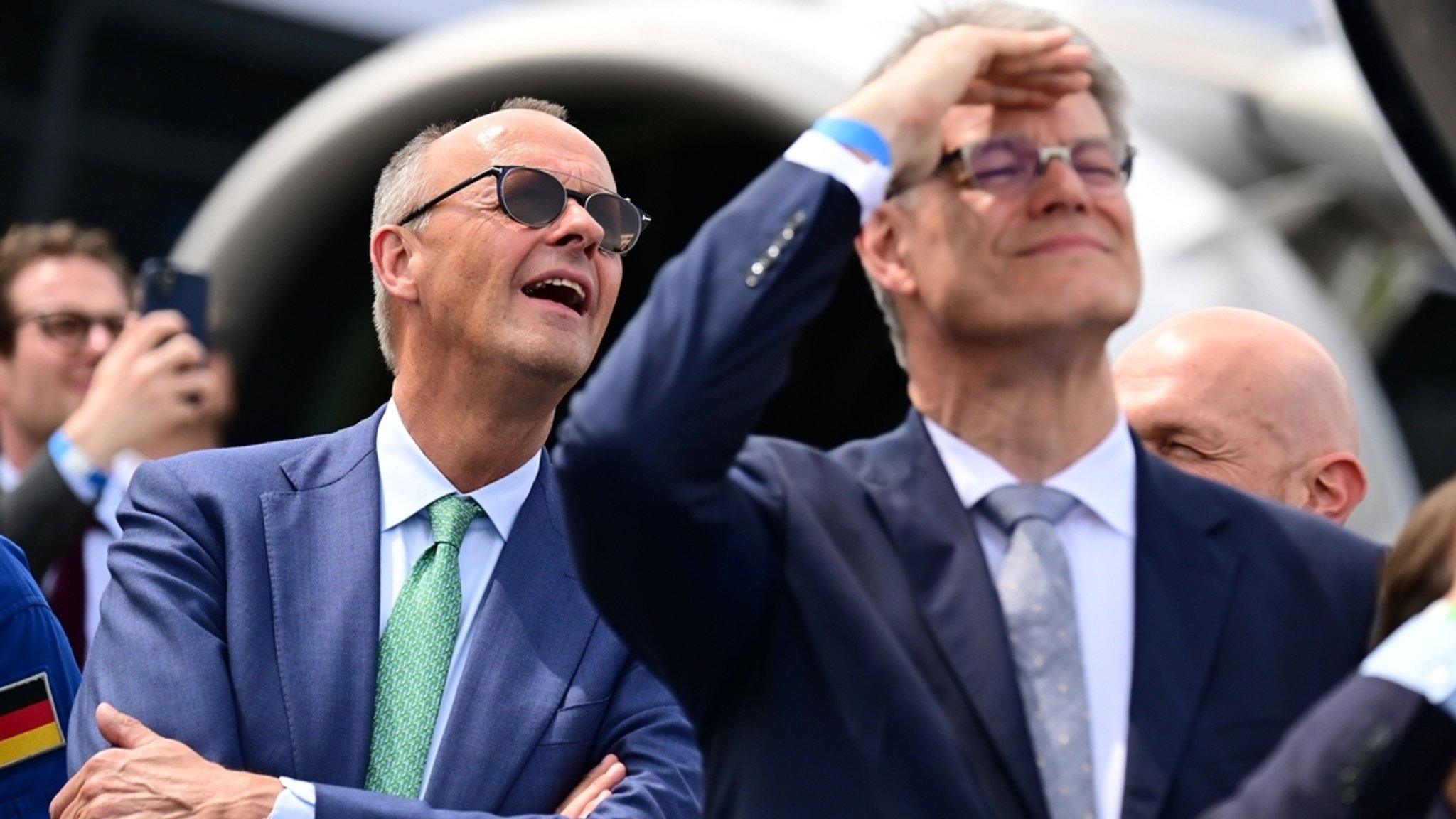 Archivbild vom 10.06.2026, Brandenburg, Schönefeld: Bundeskanzler Friedrich Merz (l, CDU) und Bundesverkehrsminister Patrick Schnieder (CDU), schauen während eines Rundgangs auf der Internationale Luft- und Raumfahrtausstellung (ILA) Fallschirmspringern zu. | Bild: dpa-Bildfunk/Sebastian Gollnow Archivbild vom 10.06.2026, Brandenburg, Schönefeld: Bundeskanzler Friedrich Merz (l, CDU) und Bundesverkehrsminister Patrick Schnieder (CDU), schauen während eines Rundgangs auf der Internationale Luft- und Raumfahrtausstellung (ILA) Fallschirmspringern zu.