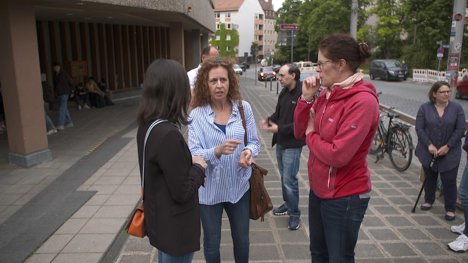 Eltern stehen diskutierend vor einer Schule. | Bild:BR/Constanze Schulze