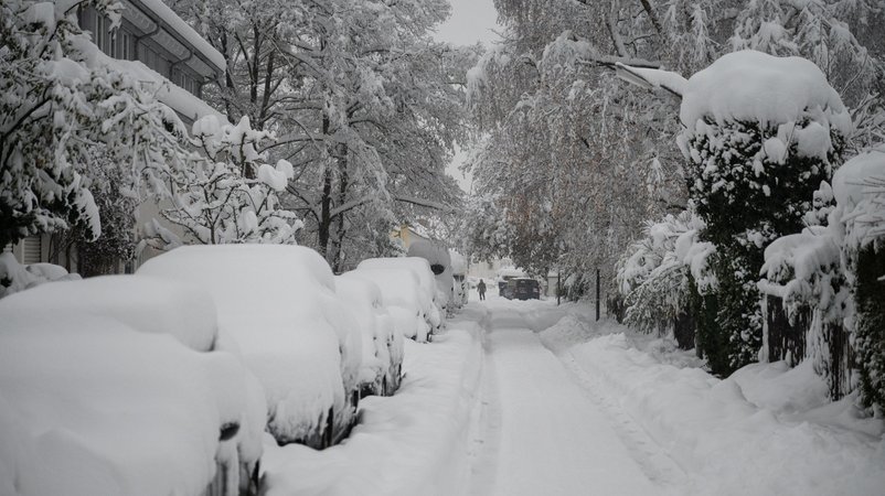 02.12.2023, Bayern, München: Hohe Schneemassen liegen auf Autos und einer Straße in der Landeshauptstadt. Schnee und Eis haben im Süden Bayerns auf den Straßen und bei der Bahn für Chaos gesorgt. Foto: Lukas Barth/dpa +++ dpa-Bildfunk +++