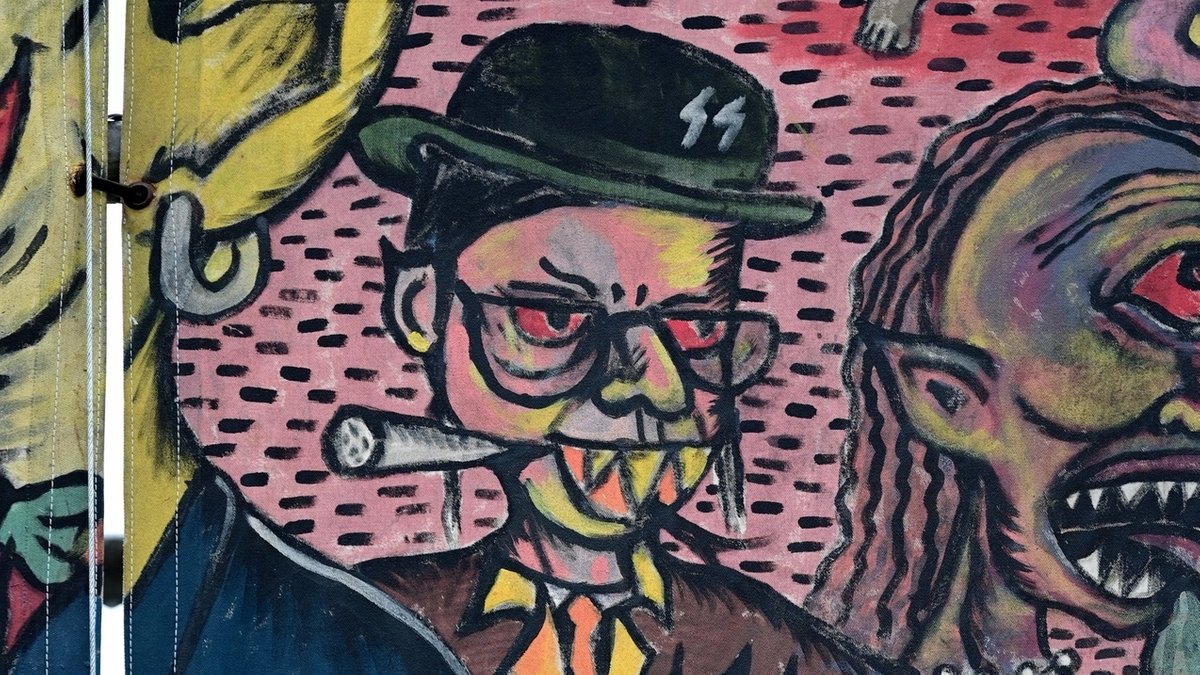 Ausschnitt aus einem bunten Gemälde zeigt das antisemitische Motiv eines Mannes mit Schläfenlocken und Raffzähnen. 