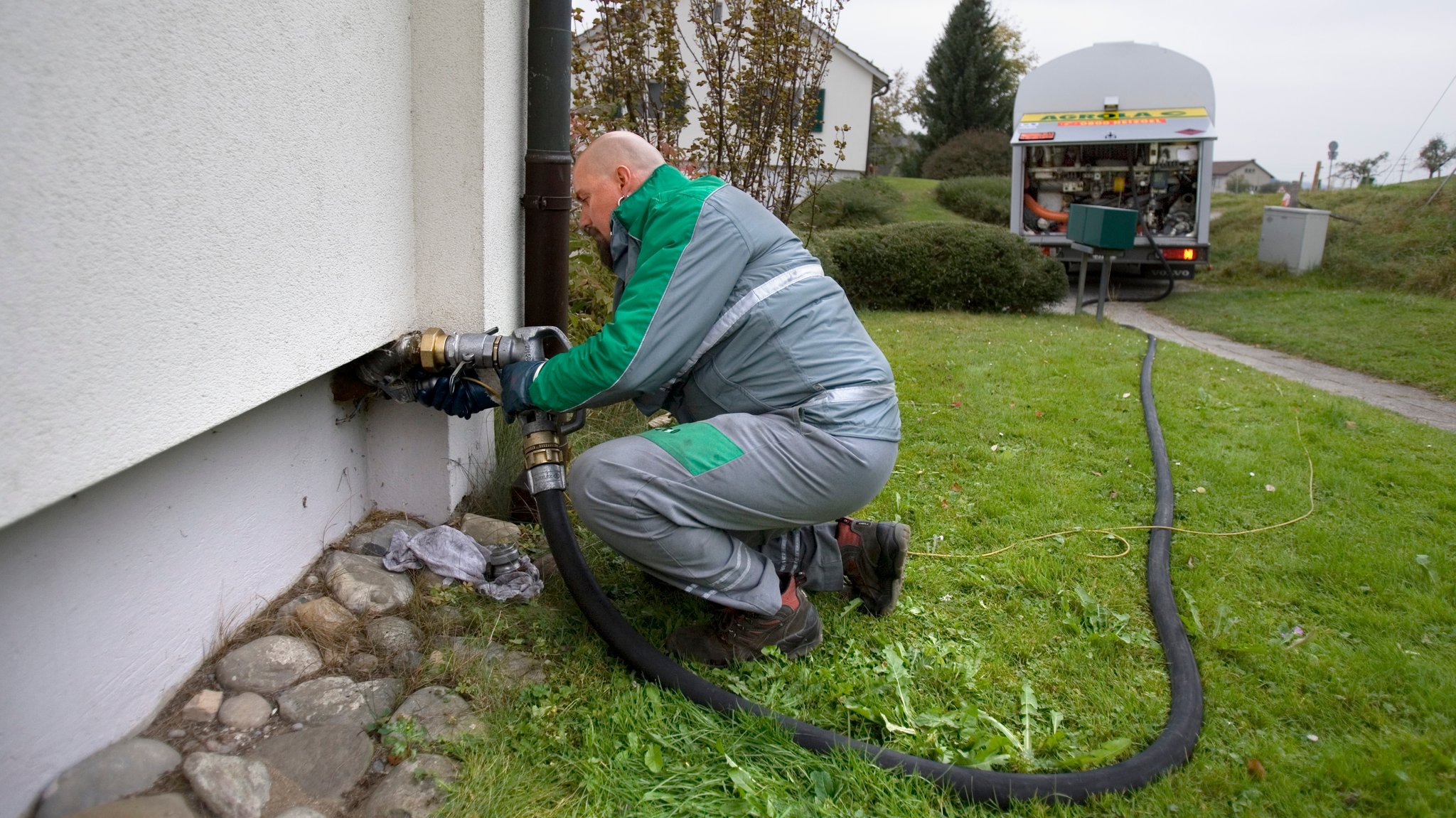 Ein Öllieferant lässt Öl in den Tank eines Privathauses ein. 