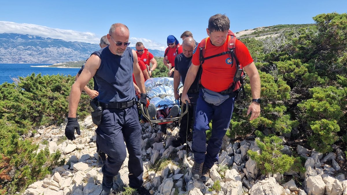 Kroatische Rettungskräfte bringen die Männer auf einer Trage über unwegsames Gelände in Sicherheit