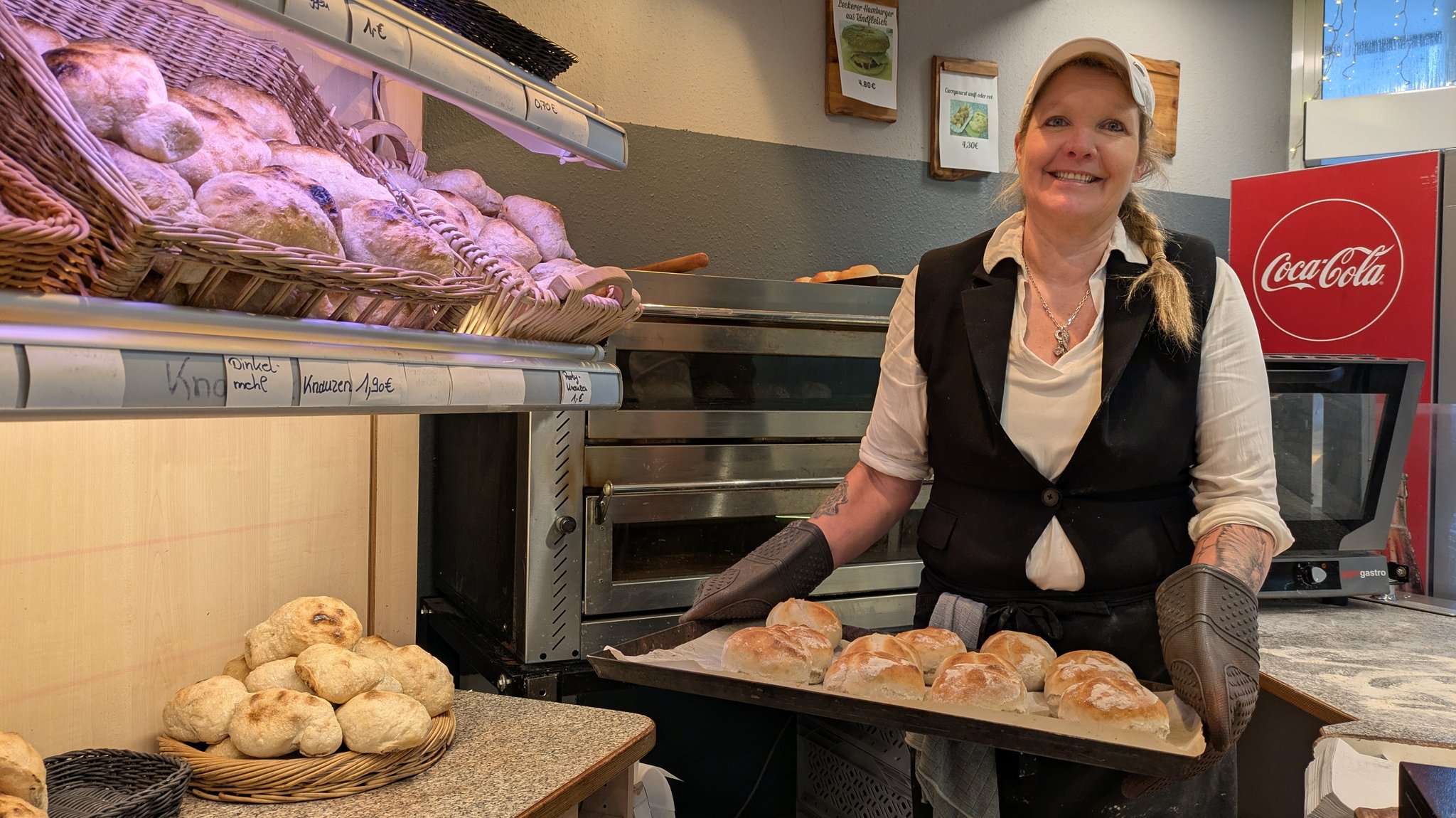 Bäckerin Manuela Lingenhöle mit einem Backblech in der Hand, auf dem Semmel liegen. | Bild: BR/Peter Allgaier Bäckerin Manuela Lingenhöle mit einem Backblech in der Hand, auf dem Semmel liegen.
