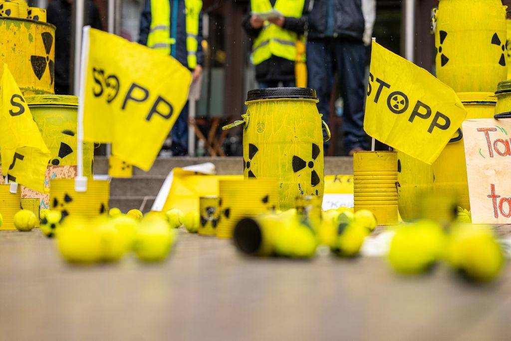 Bei der Kundgebung und Demonstration gegen die geplanten Castortransporte nach Ahaus, stehen mehrere gelbe Behälter mit einem Atomsymbol und kleine Fähnchen mit der Aufschrift: ·STOPP· auf dem Rathausplatz. 41 Initiativen haben zur Demo zur Transportstrecke aufgerufen.