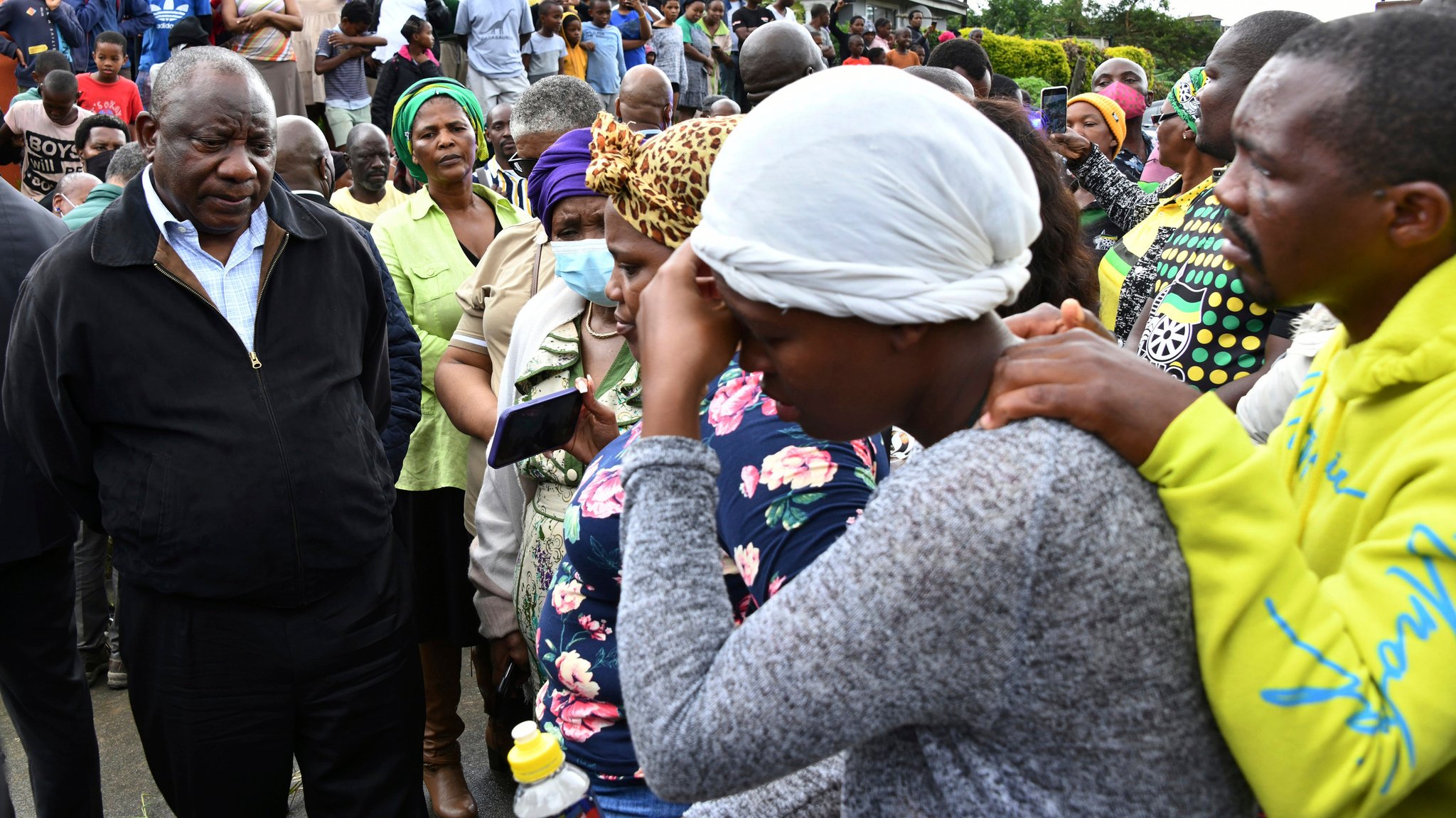 Auf diesem vom südafrikanischen Kommunikations- und Informationsdienst der Regierung (GCIS) zur Verfügung gestellten Foto spricht Cyril Ramaphosa (l), Präsident von Südafrika, mit trauernden Familienmitgliedern, während seines Besuchs, um die Schäden nach den heftigen Regenfällen zu begutachten.