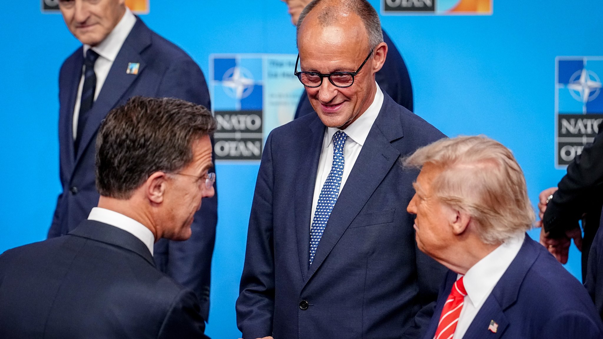 Mark Rutte (l-r), Generalsekretär der Nato, Bundeskanzler Friedrich Merz (CDU) und US-Präsident Donald Trump stehen beim Nato-Gipfel für das Familienfoto zusammen. Die 32 Staats- und Regierungschefs der Nato-Staaten treffen sich hier zu einem zweitägigen Gipfel.