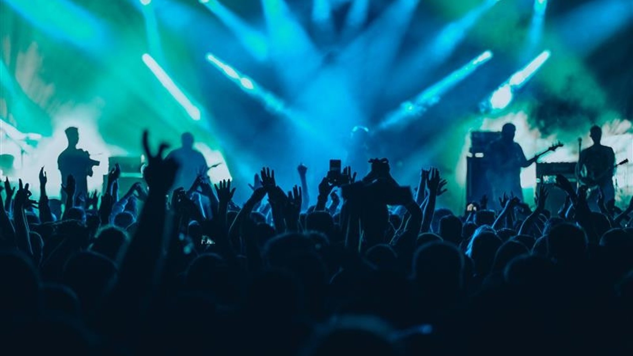 Publikum vor Band auf einer Bühne bei einem Konzert