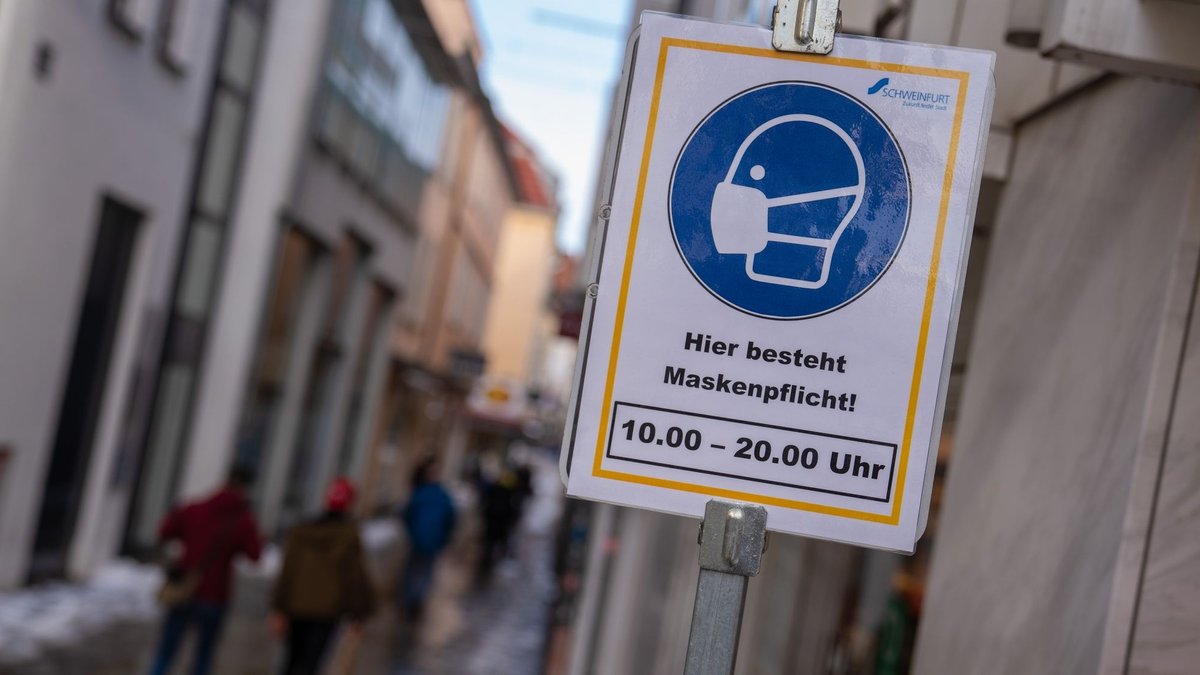 Ein Schild weist auf die Maskenpflicht in der Innenstadt von Schweinfurt hin.